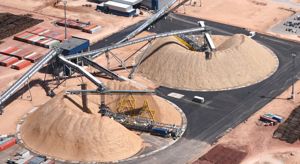 Two stacker reclaimer systems in action, stacking and reclaiming bulk materials.